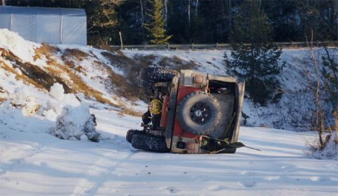 1985 Ford Bronco - An off-road vehicle lies on its side in a snowy landscape, suggesting a recent accident.