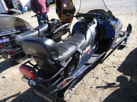 1991 Ford LTD Crown Victoria - Two Ski-Doo snowmobiles are parked outdoors on a dirt surface.