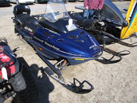 1991 Ford LTD Crown Victoria - Blue Ski-Doo Grand Touring snowmobile parked outdoors with another snowmobile behind it.