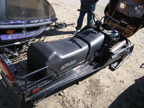 1991 Ford LTD Crown Victoria - A black Ski-Doo snowmobile is shown with its engine compartment open, parked next to another snowmobile.