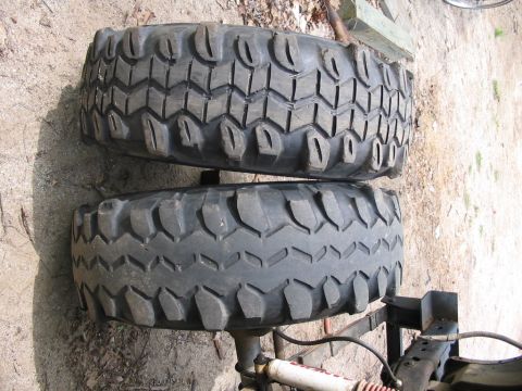 1985 Ford Bronco - Two off-road tires are stacked on top of each other, showing their tread detail.