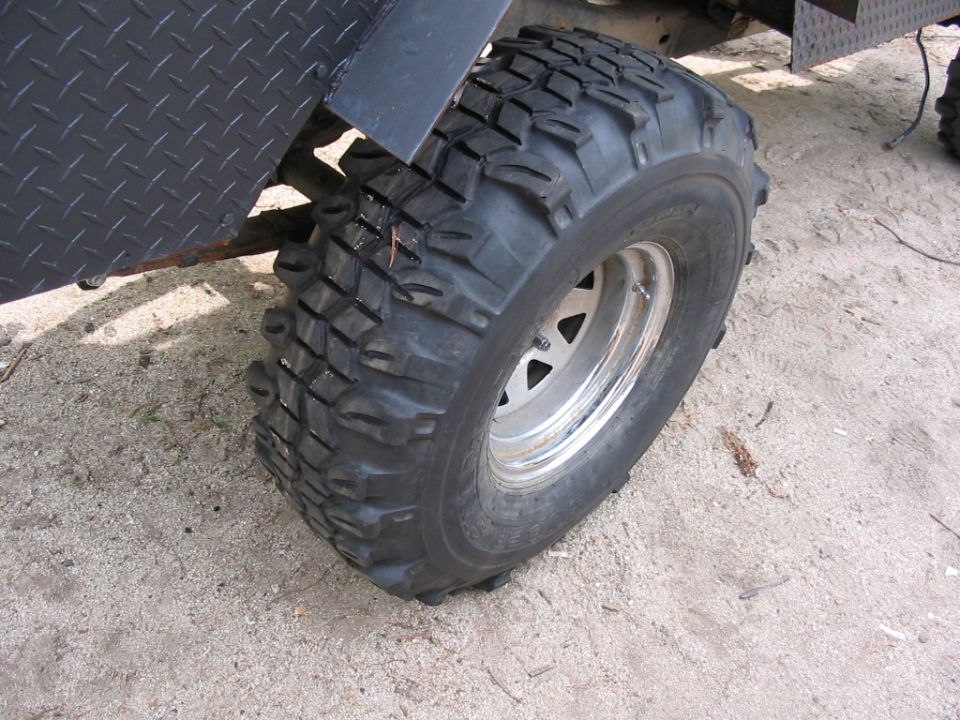 close-up of a large off-road tire and diamond plate fender on a vehicle