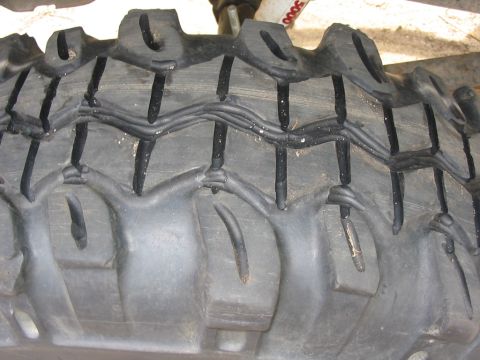 1985 Ford Bronco - A detailed view of a heavy-duty tire tread, showing its robust construction and deep, off-road-oriented pattern.