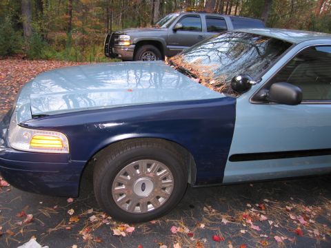 1991 Ford LTD Crown Victoria - A two-tone sedan with its driver's door ajar is parked outdoors, with another vehicle visible in the background.