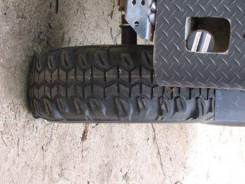 1985 Ford Bronco - Close-up view of a spare tire and a diamond plate bumper section.