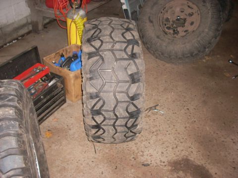 1988 Chevrolet Blazer - A close-up view of an off-road tire and a spare wheel, with tools and equipment visible in the background.