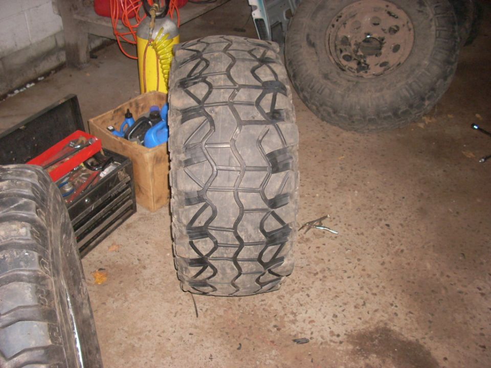 Off-road tire and spare wheel in garage with tools