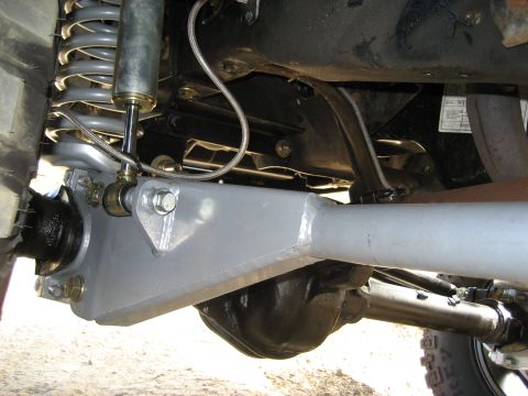 1996 Ford Bronco - The underside of a vehicle shows heavy-duty suspension parts, including a large coil spring and shock absorber.