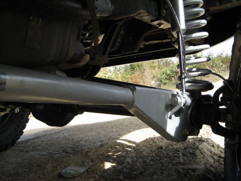 1996 Ford Bronco - Close-up view of a vehicle's modified suspension system, focusing on the rear axle and shock absorber assembly.