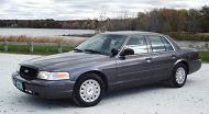 2003 Ford Crown Victoria - 2003 Ford Crown Victoria sedan in a three-quarter front view, parked near a body of water.