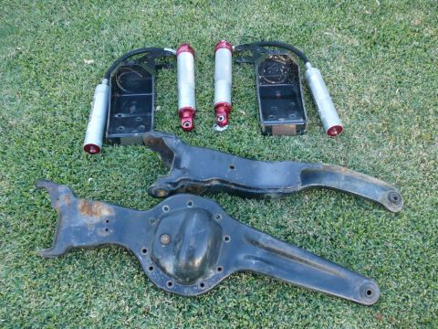1988 Ford Bronco - Various suspension parts and shocks are laid out on a grassy surface.