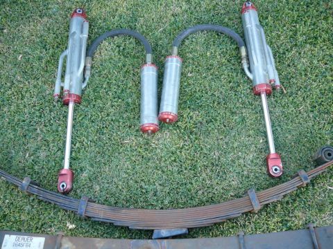 1988 Ford Bronco - Off-road suspension parts including shocks and leaf springs laid out on grass. Part number DERVER J645F64 is visible.