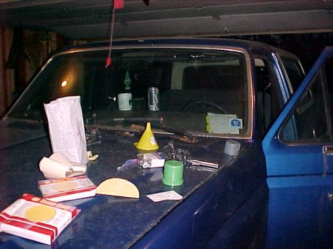 1985 Ford Bronco - Interior view of a blue SUV with various items scattered on the hood.