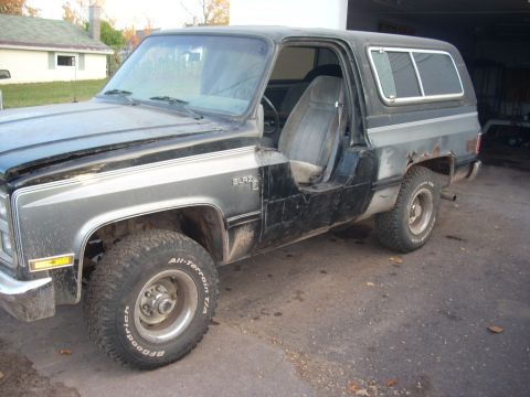 1988 Chevrolet Blazer - This two-tone Chevrolet Blazer is missing its driver's side door and shows some rust on the rear quarter panel.