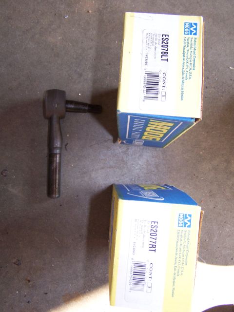 1986 Ford Bronco - Two boxes of Moog tie rod ends are shown next to a loose tie rod end part on a concrete surface.