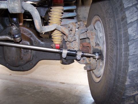 1986 Ford Bronco - This photo shows the detailed front steering and suspension system of a vehicle, including the differential housing and tie rod ends.