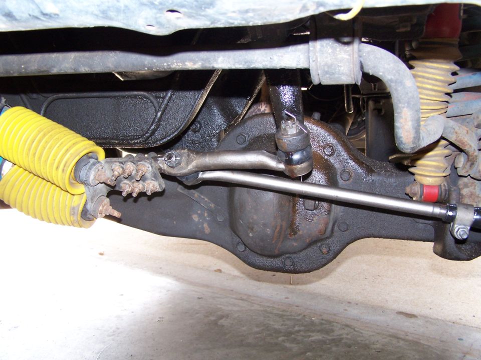 1986 Ford Bronco front axle and suspension components, yellow shocks, some rust and grease