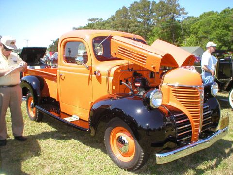 1991 Ford Bronco - A classic orange pickup truck is displayed with its hood open, revealing the engine compartment.