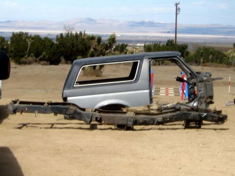 1996 Ford Bronco - The body and chassis of a 1996 Ford Bronco are shown separated in an outdoor setting.