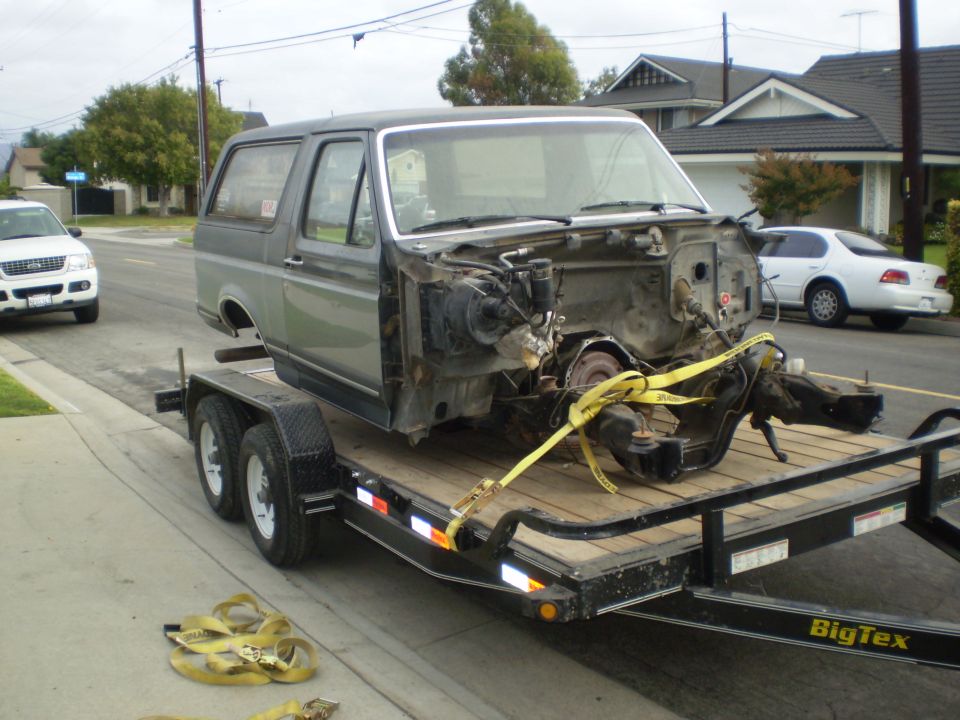 1996 Ford Bronco body on a trailer, chassis underneath, disassembled.