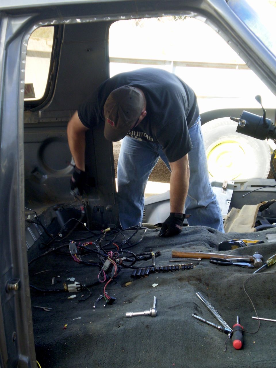 Person working on car interior with tools and wiring