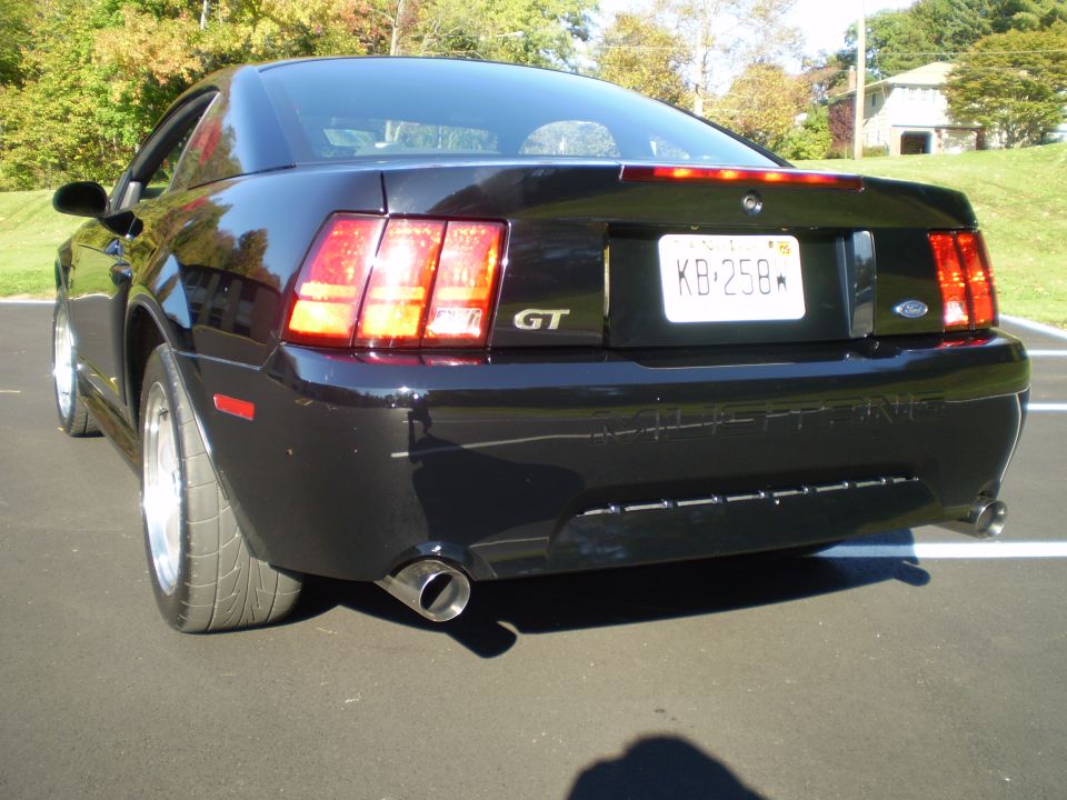 Black 2002 Ford Mustang GT rear driver's side quarter view, showing dual exhaust and license plate KB-258.