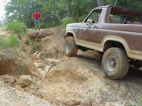 1985 Ford Bronco - A brown Ford Bronco navigates a challenging off-road course.