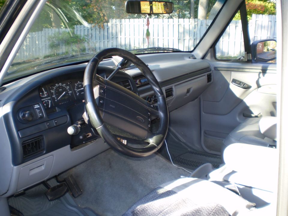 Interior of a 1996 Ford Bronco, showing dashboard, steering wheel, and seats.