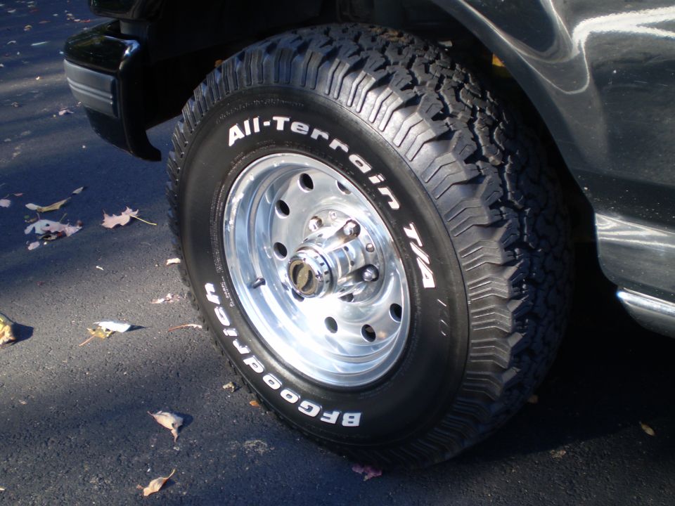 BFGoodrich All-Terrain T/A tire on a chrome wheel of a black Ford Bronco.