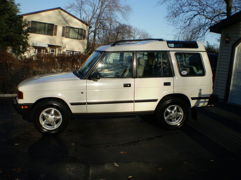 White Land Rover Discovery in side profile parked on a driveway