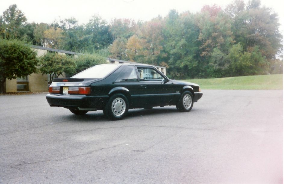 Black 1988 Ford Mustang coupe parked in an asphalt lot.