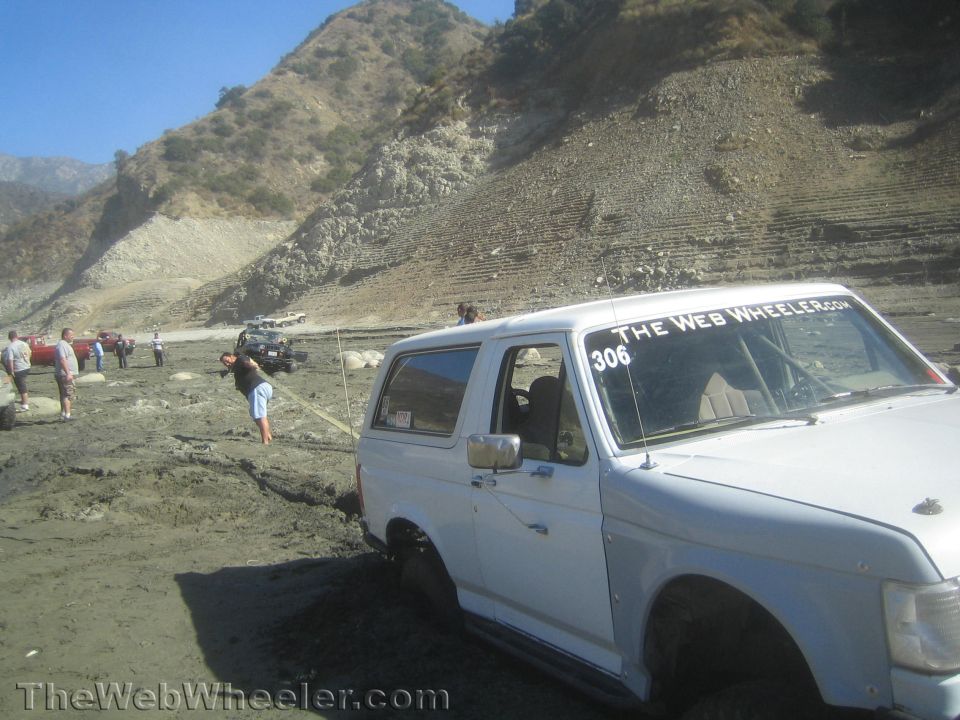 White Ford Bronco at an off-road event with bystanders in a canyon