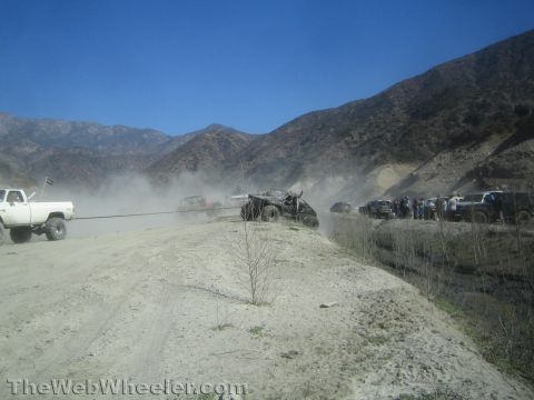 1990 Ford Bronco - Photo of off-road trucks on a dusty canyon road, not a technical document.
