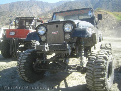 1990 Ford Bronco - Photo of a black Jeep CJ rock crawler on dirt, not a technical document.