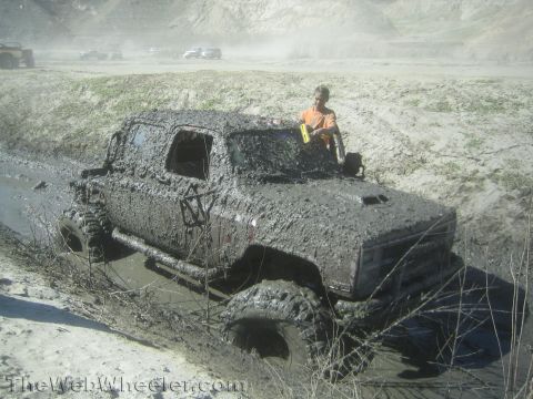 1990 Ford Bronco - Photo of a mud-coated Chevy Blazer mired in a ditch, not a technical document.