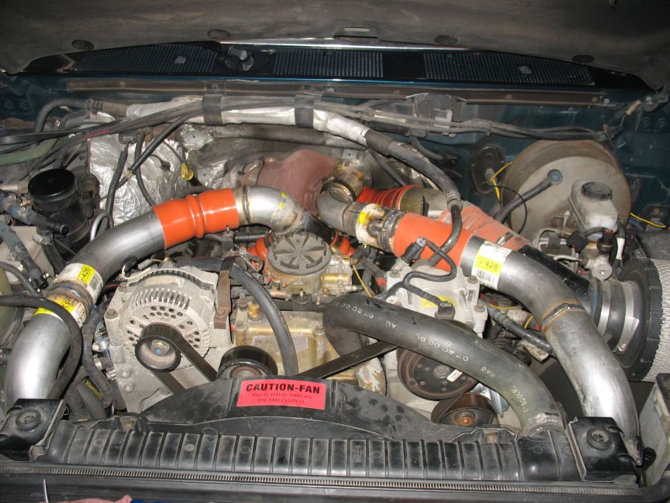 Ford C-350 engine bay with turbo piping, alternator, and radiator.