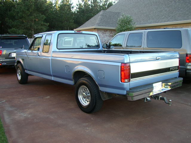 Light blue Ford pickup truck parked on driveway.
