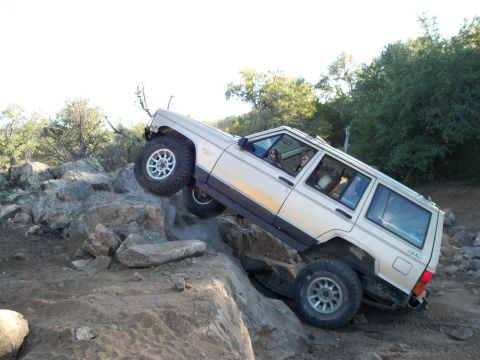 1996 Ford Bronco - This Jeep Cherokee XJ is navigating a challenging rocky terrain during an off-road excursion.