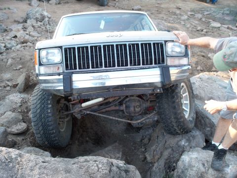 1996 Ford Bronco - A Jeep Cherokee navigates a rocky obstacle course during an off-road event.