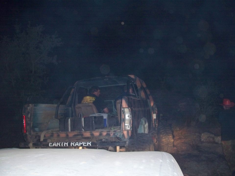 Camouflaged off-road vehicle with "EARTH RAPER" text on the rear bumper, seen at night