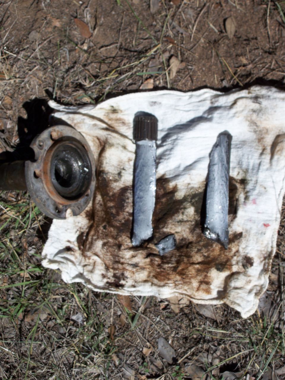 Broken axle shaft pieces and a hub assembly on a stained cloth