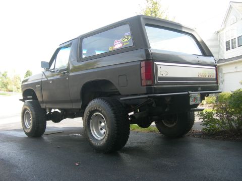 1985 Ford Bronco - This lifted Ford Bronco features an aftermarket rear bumper and large off-road tires.