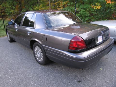 2001 Ford Crown Victoria - This Ford Crown Victoria is seen from the rear quarter angle, parked outdoors with autumn foliage visible.