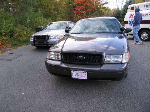 2001 Ford Crown Victoria - Two Ford Crown Victorias are parked on a street, with an ambulance visible in the background.