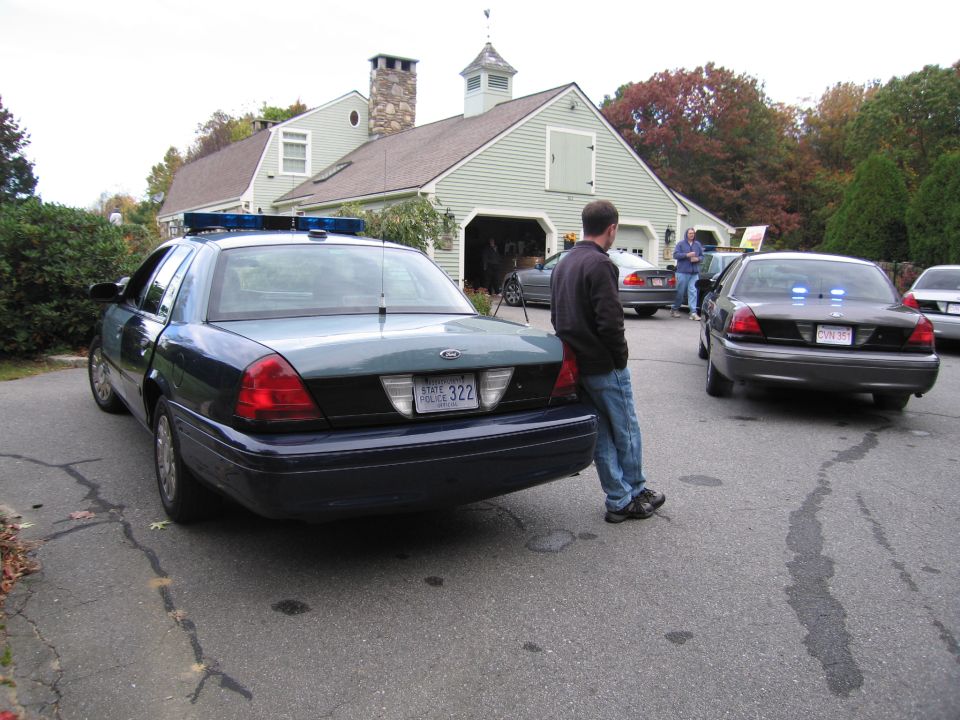 Two police cars parked in front of a building, one with its rear facing the camera
