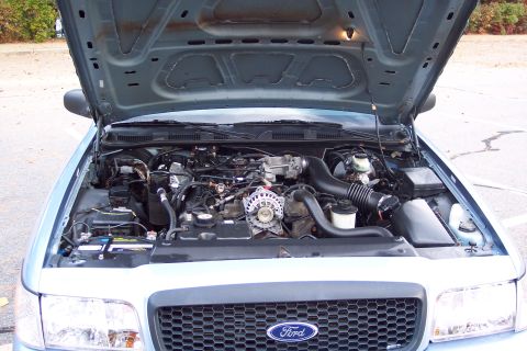 2001 Ford Crown Victoria - The engine compartment of a 2001 Ford Crown Victoria is displayed with the hood fully open.