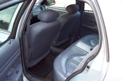 2001 Ford Crown Victoria - Rear interior view of a 2001 Ford Crown Victoria, highlighting the blue cloth seats and door trim.