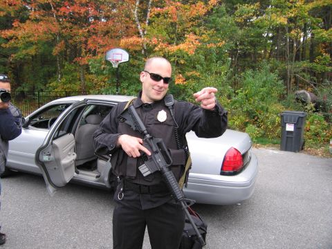 2001 Ford Crown Victoria - Police officer stands next to a 2001 Ford Crown Victoria with the driver's door open.