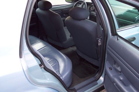 2001 Ford Crown Victoria - The interior of a 2001 Ford Crown Victoria is shown, with a focus on the rear seating area and the driver's side door.