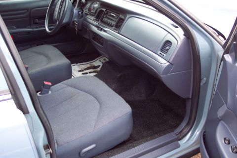 2001 Ford Crown Victoria - The interior of a 2001 Ford Crown Victoria is shown, cloth seats and a standard dashboard layout.